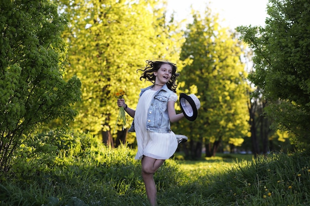 Fille dans le parc le soir d'une journée ensoleillée au printemps