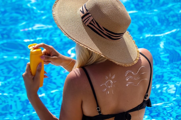 Fille dans la piscine frottis écran solaire reste mise au point sélective