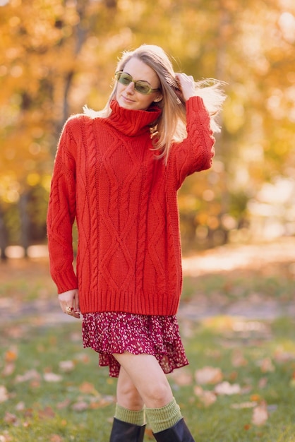 une fille dans un pull rouge se promène en automne dans le parc le concept de la saison d'automne