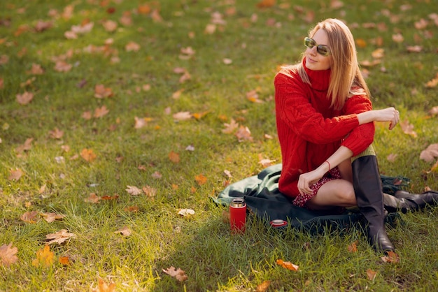 une fille dans un pull rouge se promène en automne dans le parc le concept de la saison d'automne