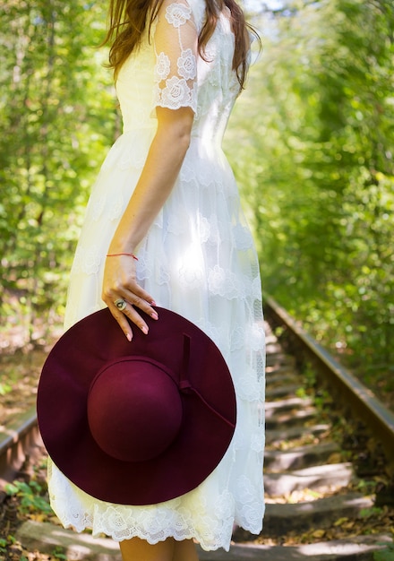 Une fille dans une robe blanche avec un chapeau de cerise en bois