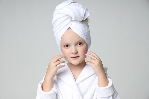 Fille dans une robe blanche et une serviette sur la tête