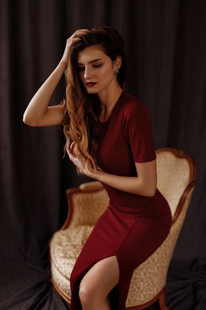 fille dans une robe bordeaux sur fond de tissu