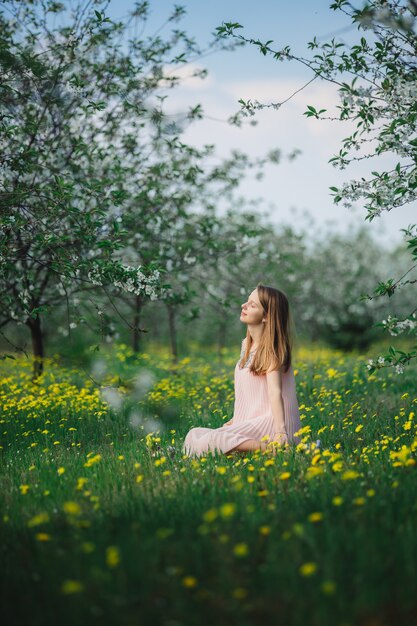 fille dans une robe rose dans un jardin fleuri