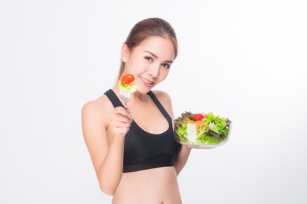 Fille dans une salle de fitness détient un saladier.