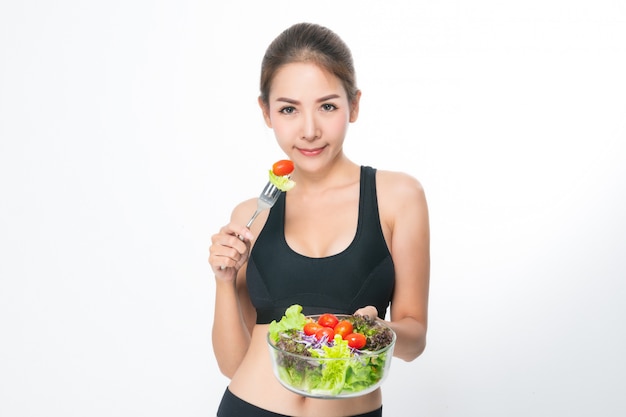 Fille dans une salle de fitness est titulaire d&#39;un saladier.