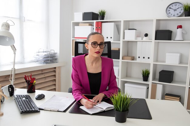 Une fille dans un style professionnel travaille avec des documents au bureau