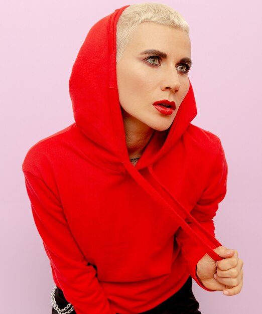 Fille dans un sweat-shirt rouge aux cheveux courts. Style de mode de rue