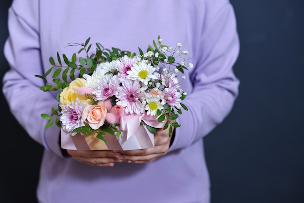 Une Fille Dans Un Sweat-shirt Violet Doux Tient Un Bouquet Dans Ses Mains.