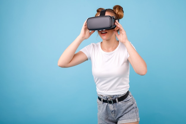 Fille dans un T-shirt blanc et des lunettes de réalité virtuelle dans l'espace