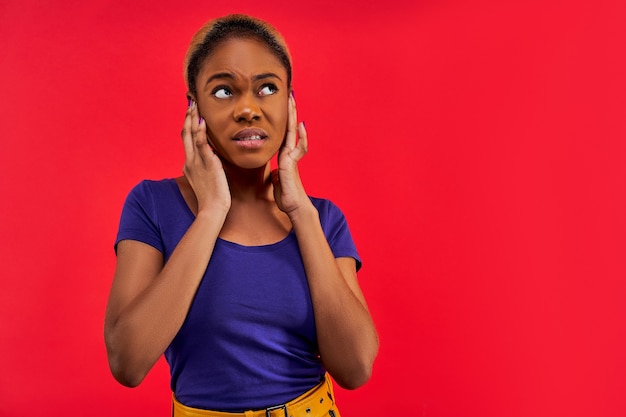 Fille Dans Un T-shirt Bleu Dans Une Jupe Jaune Pose Et Couvre Ses Oreilles Avec Ses Mains