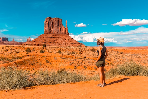 Une fille dans un t-shirt noir à Monument Valley National Park dans les mitaines et Merrick Butte point