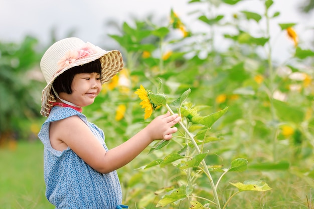 Fille dans le tournesol de jardin