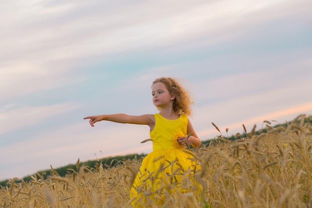 Fille debout sur le champ contre le ciel