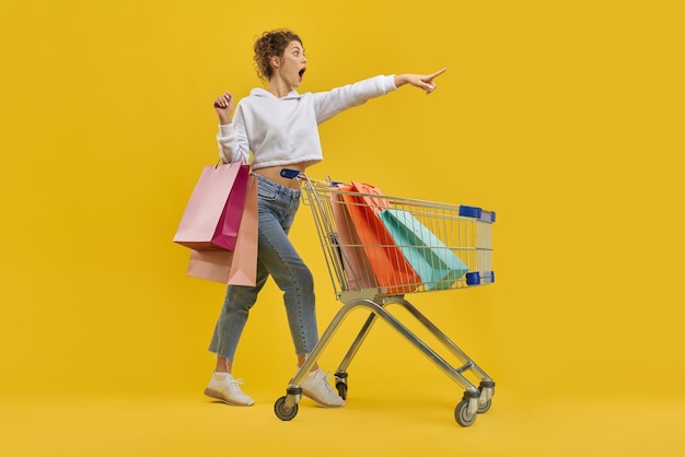 Fille debout avec des colis et un chariot criant