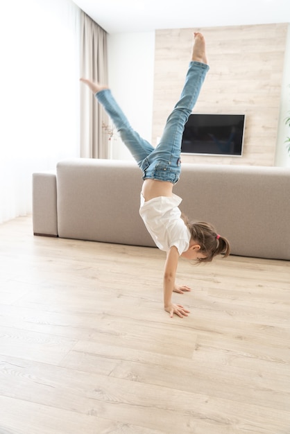 Fille debout à l'envers sur ses bras à la maison