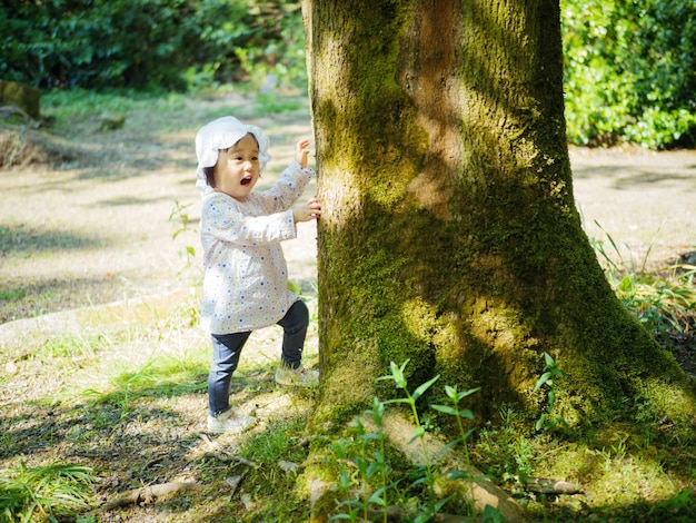 Photo une fille debout près d'un arbre