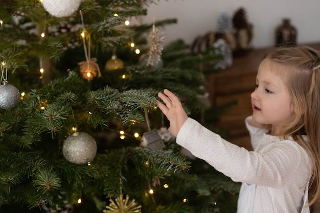 La fille décore un arbre pour Noël