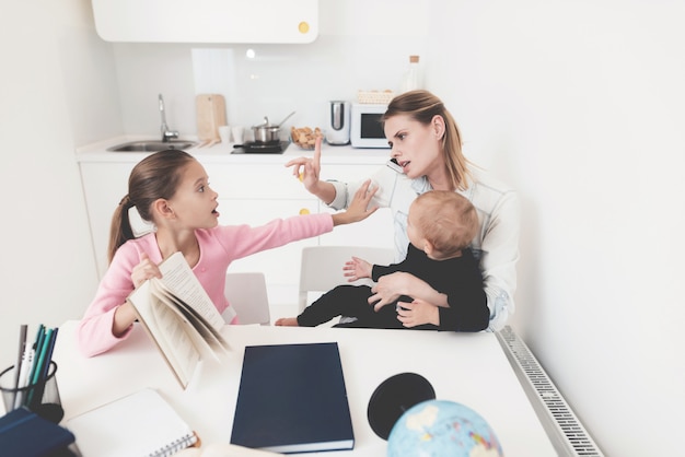 La fille demande de l'aide pendant que maman parle au téléphone