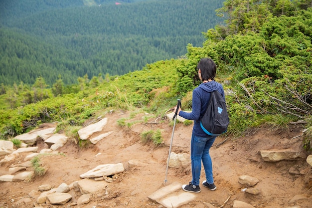 La fille descend une grande chaîne de montagnes vertes