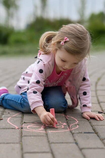 Fille dessinant à la craie sur le trottoir