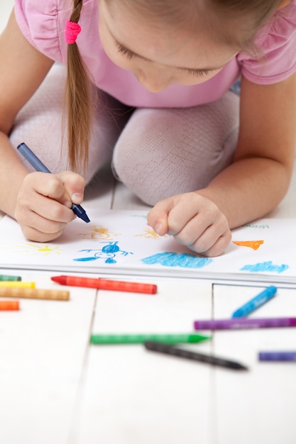 La fille dessine avec des crayons dans l'album