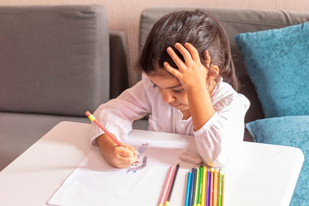 Fille dessine et peint à une petite table