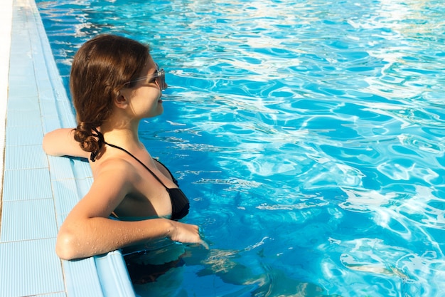 Fille de détente près de la piscine. vacances d&#39;été