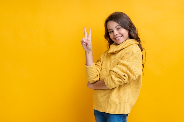 Fille avec deux doigts levés souriant