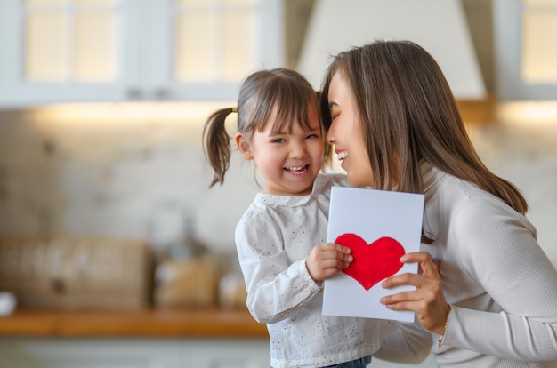 Fille donnant une carte postale à la mère le jour de la fête des mères bonne fête des mères