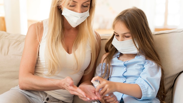 Fille donnant un désinfectant pour les mains à la mère