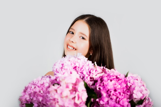 Fille douce enfant en bas âge floral, bouquet de fleurs dans les mains.