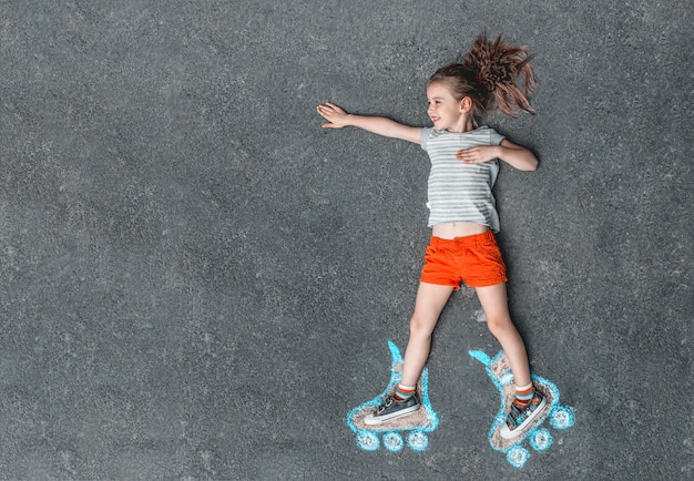 Fille douce en patins à roulettes peints à la craie