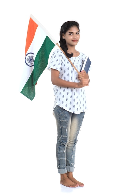Fille avec drapeau indien ou tricolore et livre sur mur blanc, jour de l'indépendance indienne, jour de la République indienne