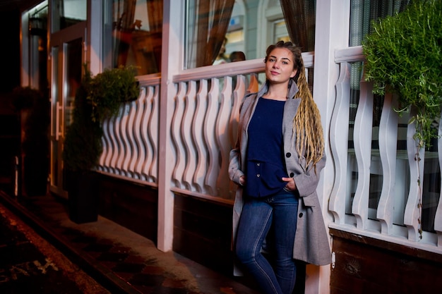 Fille avec des dreadlocks marchant la nuit rue de la ville