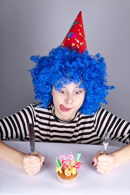 Fille drôle aux cheveux bleus avec un gâteau.