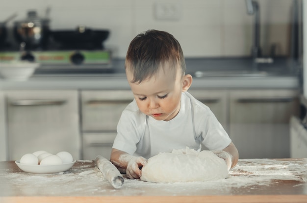 Fille drôle d'enfant préparant des biscuits, style de vie, vrai intérieur nordique, style rustique, le fond en bois brun et rouge