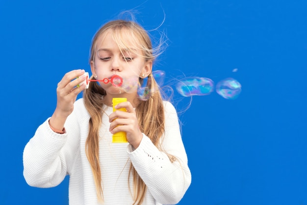 Fille drôle soufflant des bulles de savon