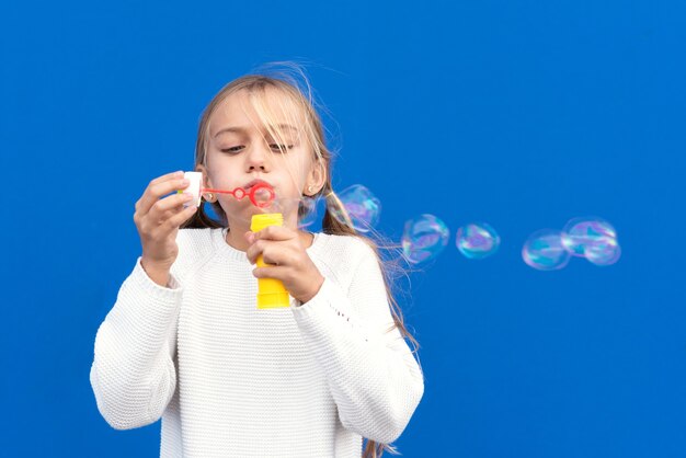 Fille drôle soufflant des bulles de savon