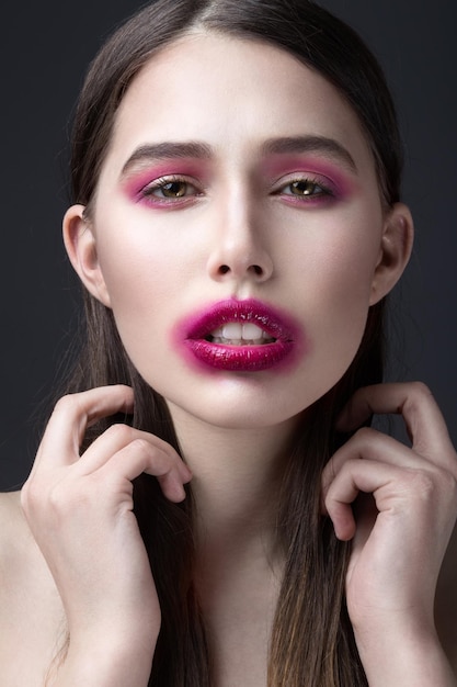 Fille avec du rouge à lèvres rose étalé sur son visage Maquillage créatif