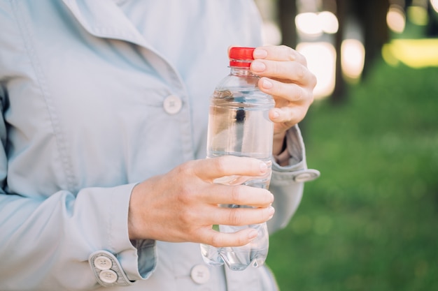 Fille avec de l'eau en plastique dans les mains