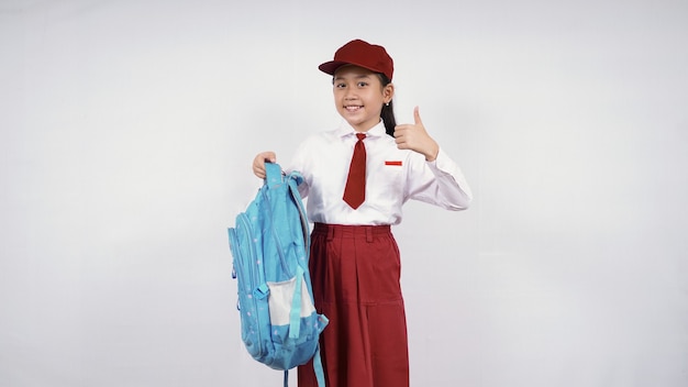 Fille de l'école élémentaire asiatique sac de transport et d'accord isolé sur fond blanc