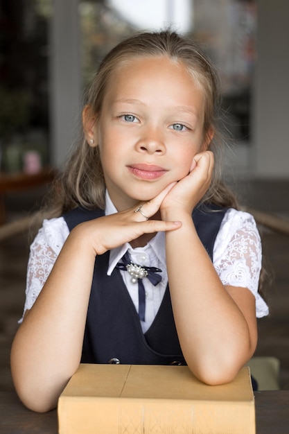 Fille de l'école primaire en uniforme scolaire avec un livre