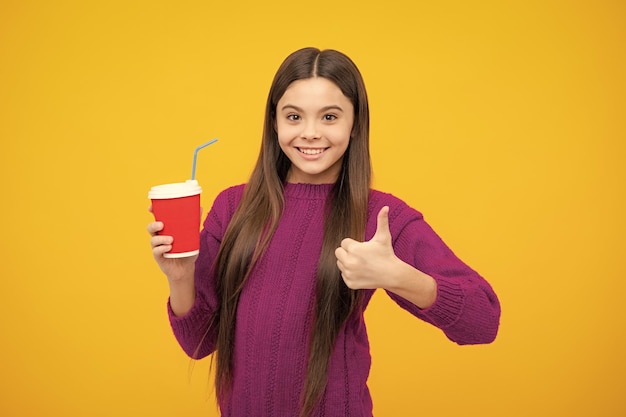 Fille de l'école avec une tasse à emporter de cappuccino ou de thé Enfant avec une tasse à emporter en plastique boisson de cacao du matin