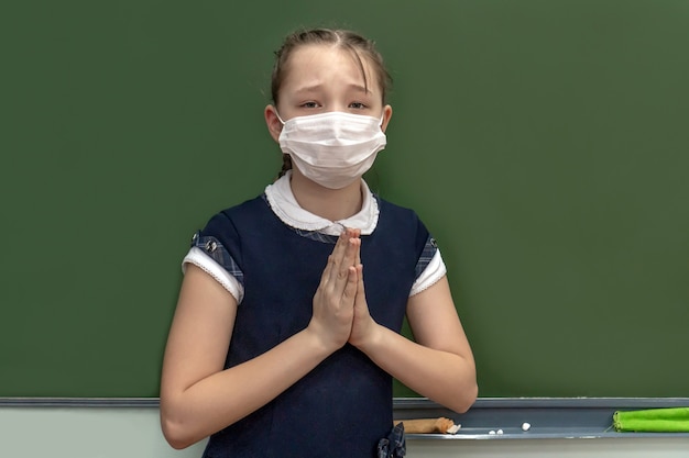 Une fille à une écolière avec un masque médical