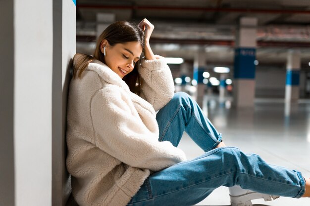 Photo fille écoutant de la musique dans le parking souterrain