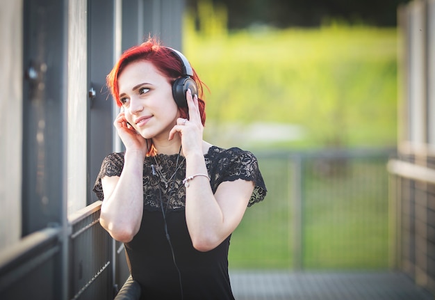 Fille écoutant de la musique via des écouteurs dans la rue.