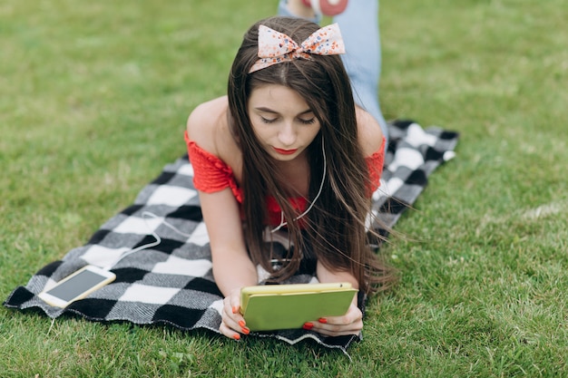 Une fille écoute de la musique sur un casque avec votre smartphone et utilise un gadget