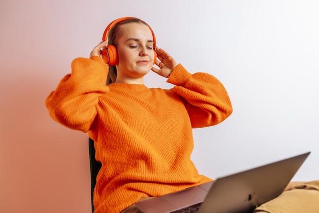 Fille écoute de la musique dans des écouteurs à l'ordinateur