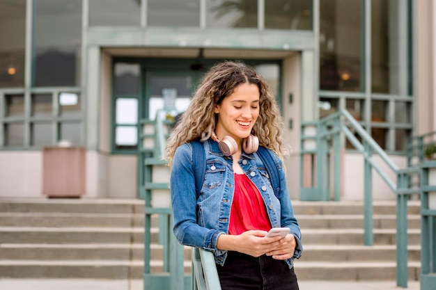 Fille avec des écouteurs, vérifiant le téléphone